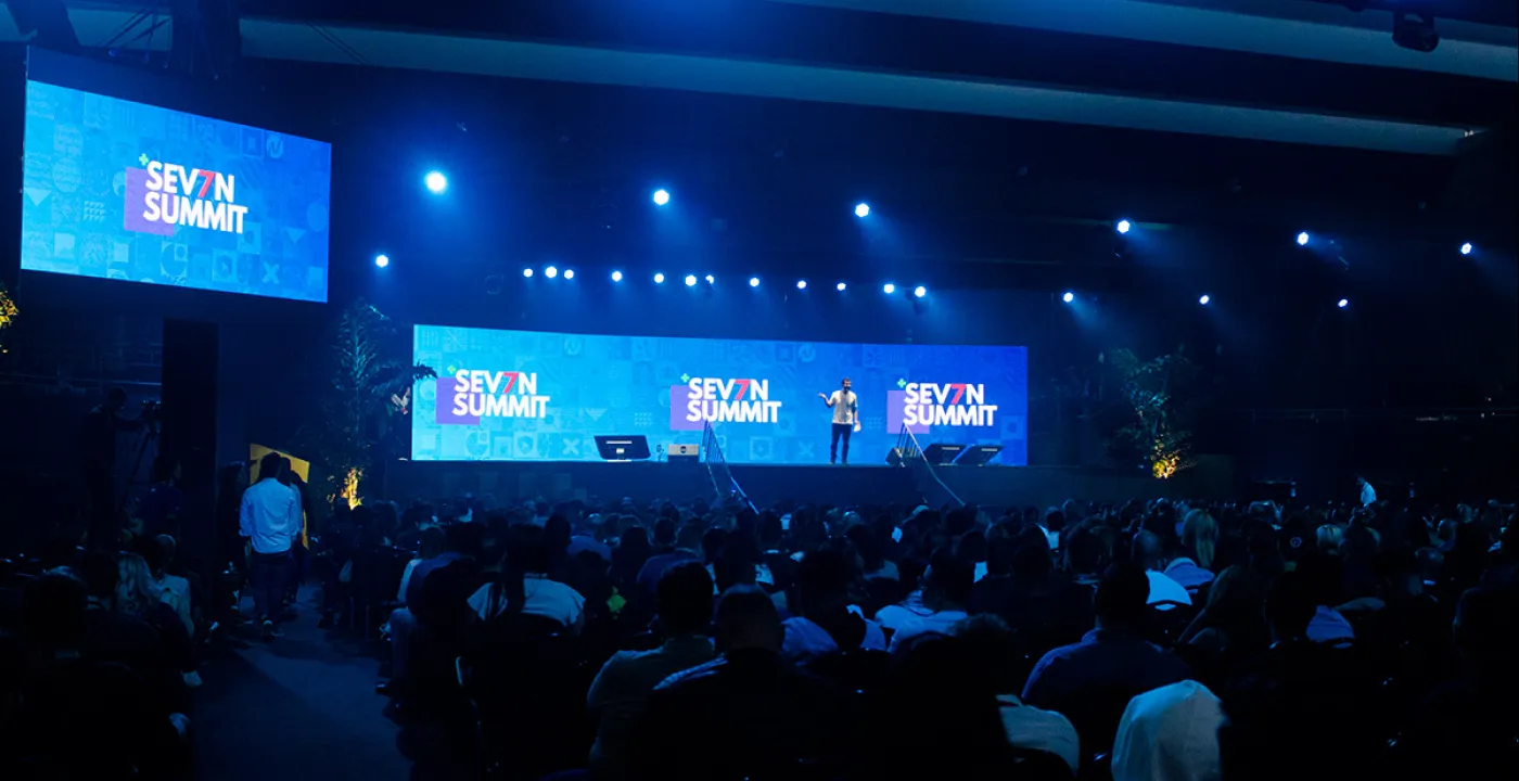Telões do palco principal com a identidade do Seven Summit e plateia
